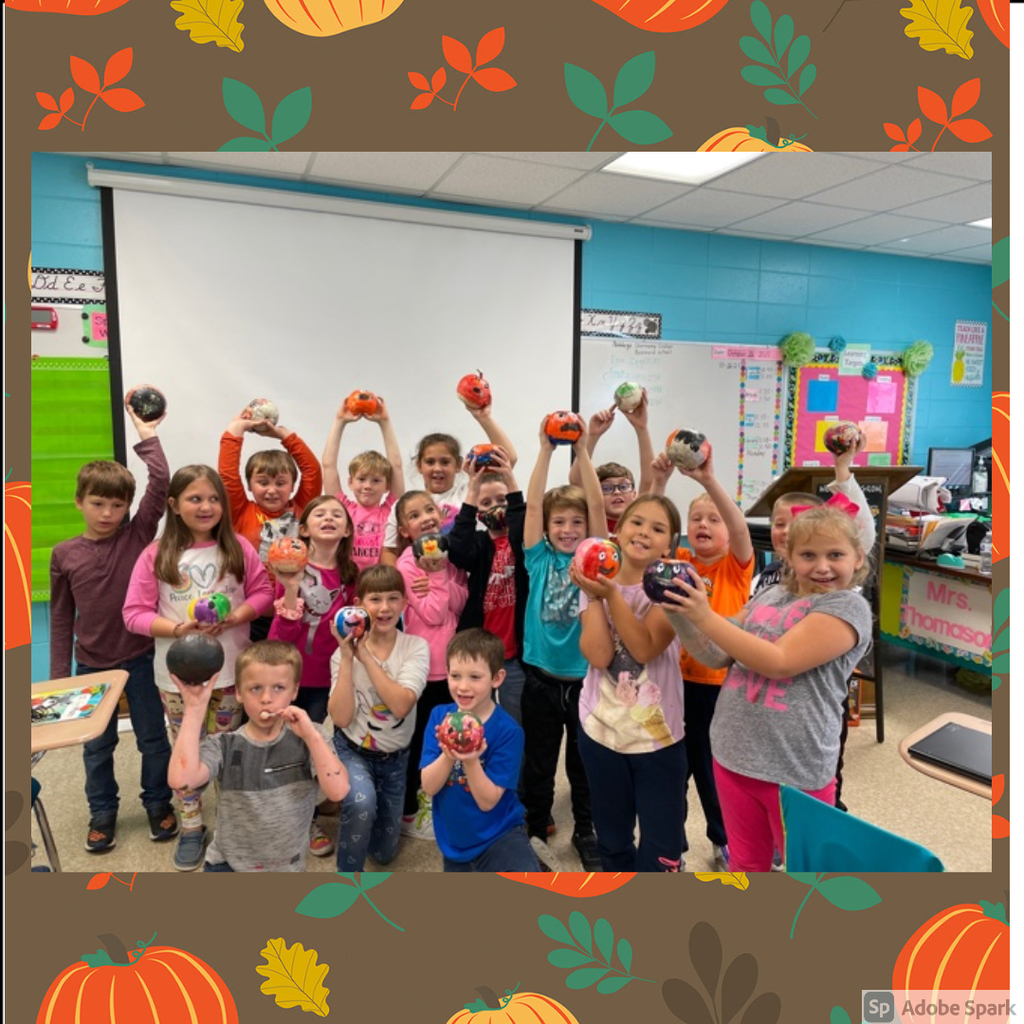 2nd graders holding painted pumpkins